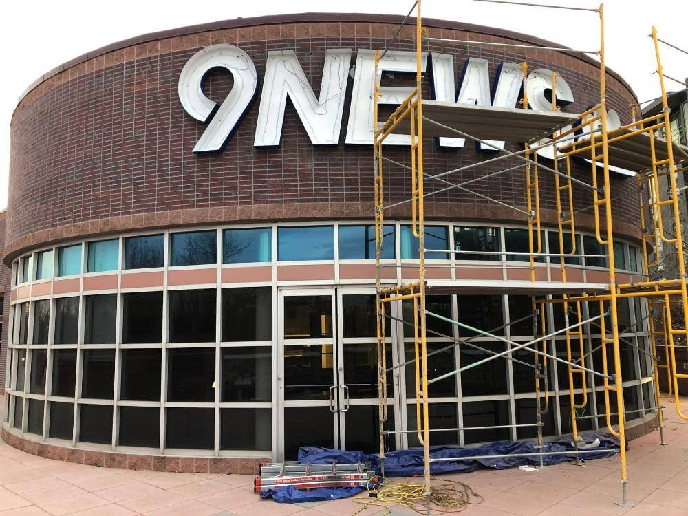 9 News LED illuminated channel letters installation services on scaffold Denver CO