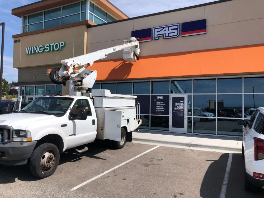 F45 exterior illuminated channel letter bucket truck installation services Parker CO